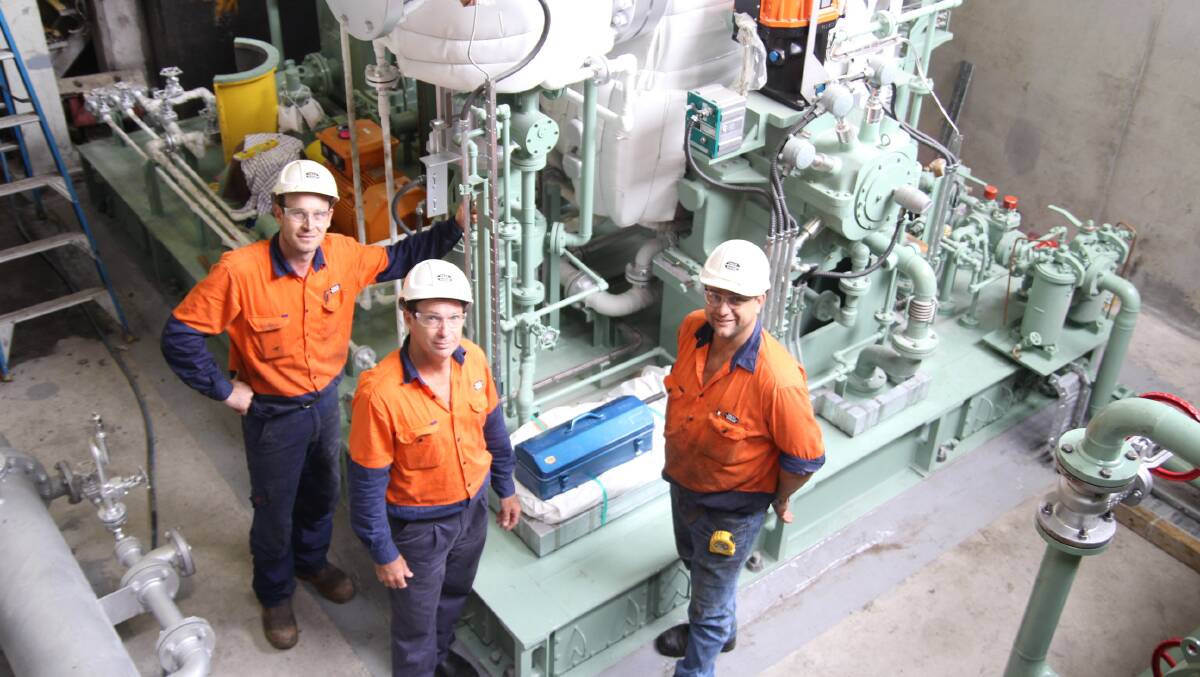 Tully Sugar staff Brendan Evans, Graham Edwards and Ian Marzona stand near the new turbine that will help double the power to the cane shredder.