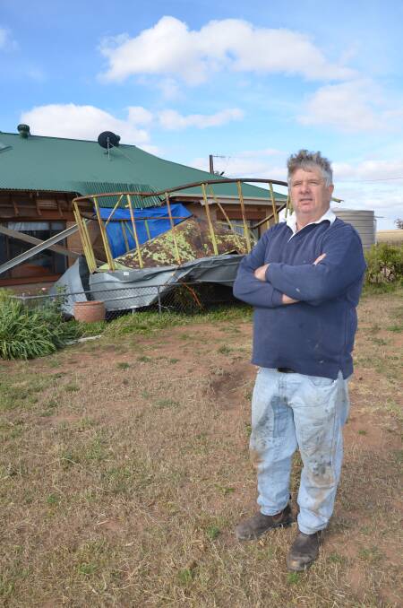 LUCKY ESCAPE: Bowhill graingrower Ham Ackland with the empty grain field bin that flew above his shed and into the side of his house during the storm on Friday. 