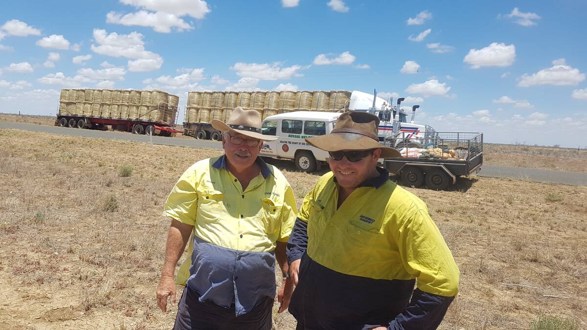 Aussie Helpers founder, Brian Egan, pictured delivering hay with Dave Church at Aramac on Australia Day, is appealing to corporates looking to demonstrate social responsibility for funding for its innovative mental health texting service for rural people. Photo supplied.
