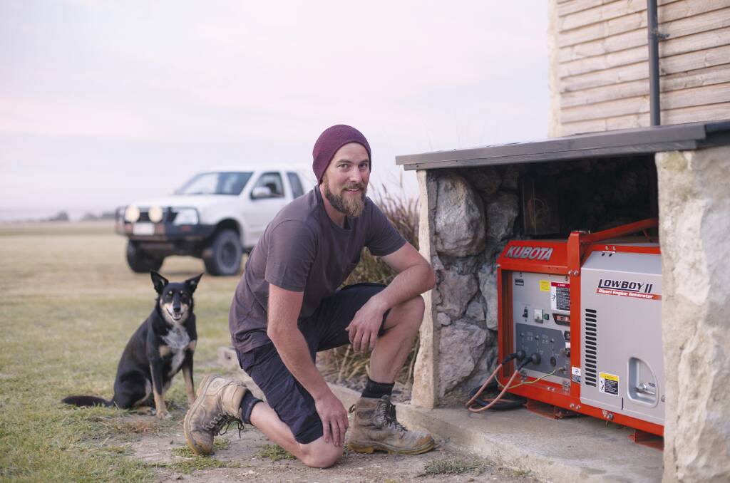 Mike Holden and kelpi Leela inspect the Kubota two pole, silent type, direct coupled, single phase diesel generator.