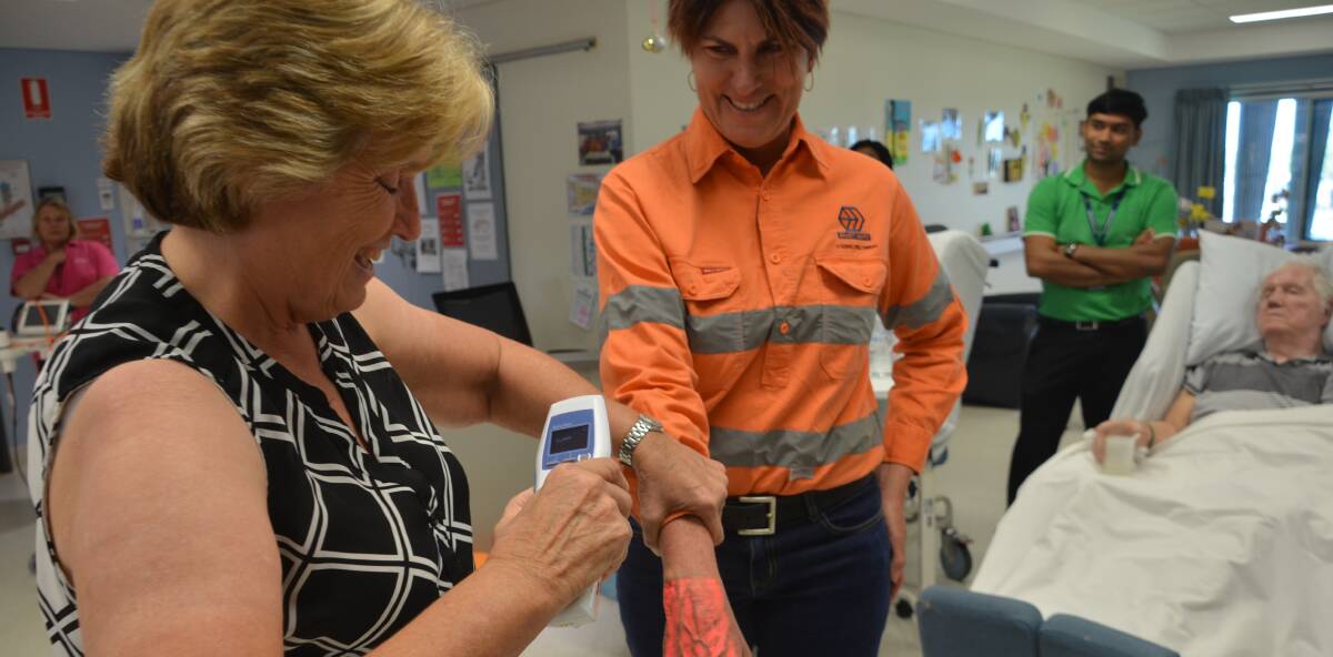 NOT IN VEIN: Cloncurry Hospital DON Leslie Laffey tries out the vein illumination device on Ernest Henry's Julia Mansfield. Photo: Derek Barry