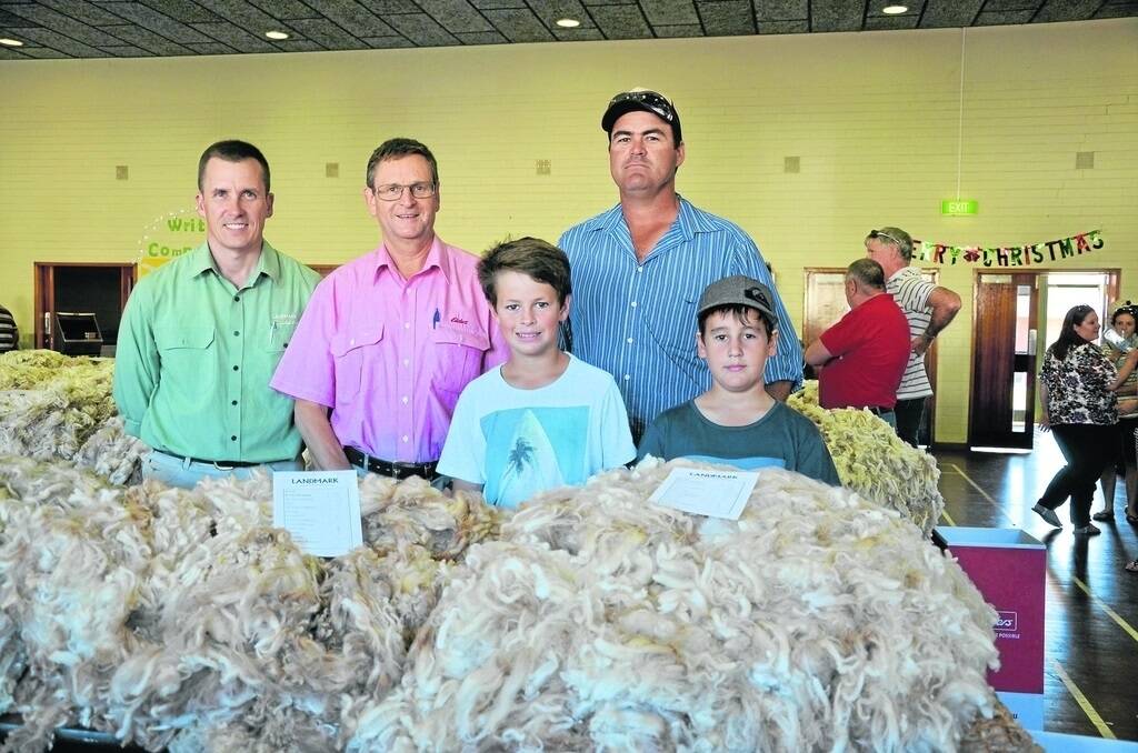 WINNING WOOL: Landmark SA wool operations manager Adrian Dewell and Elders district wool manager Charlie Rowe congratulate champion fleece winner Daniel Hatcher, The Oaks, Hawker, and his sons Charlie and Eddie.