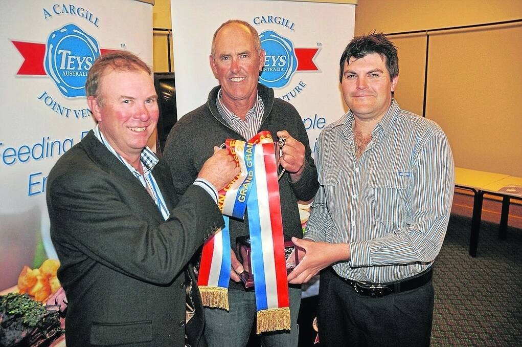 Southern Grassfed Carcase Competition chairman Allan Kain and Teys Australia's Marc Freeman congratulate Chris Bateman (centre), Furner, on winning grand champion carcase for an 18mo steer.