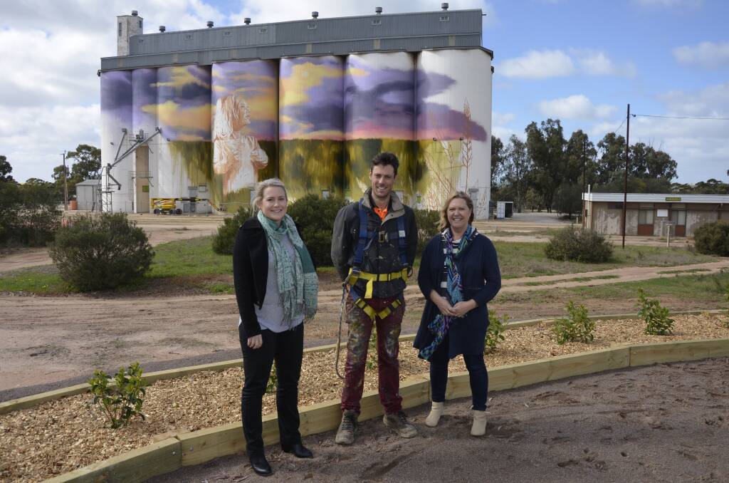 SILO WORK: Igniting Kimba working committee members Georgie Shirley and Sue Woolford, with mural artist Cam Scale (centre) in front of the Kimba silos.