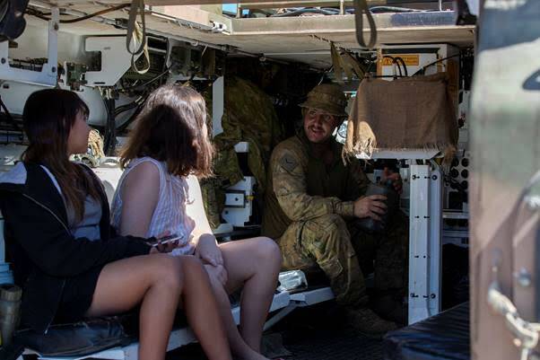 Australian Army soldier Lance Corporal Garry Wilson, from 3rd Battalion, Royal Australian Regiment, with two local residents in an Australian Army M113 Armoured Personnel Carrier, at the community engagement day in Bowen, Queensland, during Exercise Talisman Sabre 2021.