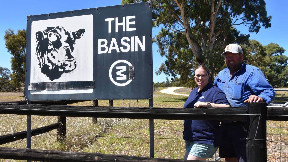 Amanda and Heath Nickolls, Bull Oak Well Angus stud at The Basin sign which still stands at the Willalooka property's entrance. 
