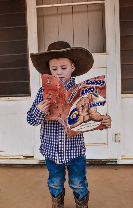 Four-year-old Roy Nunn from Wooltana Station via Copley reads the new book 'Where are Cowboy Roy's Boots?'