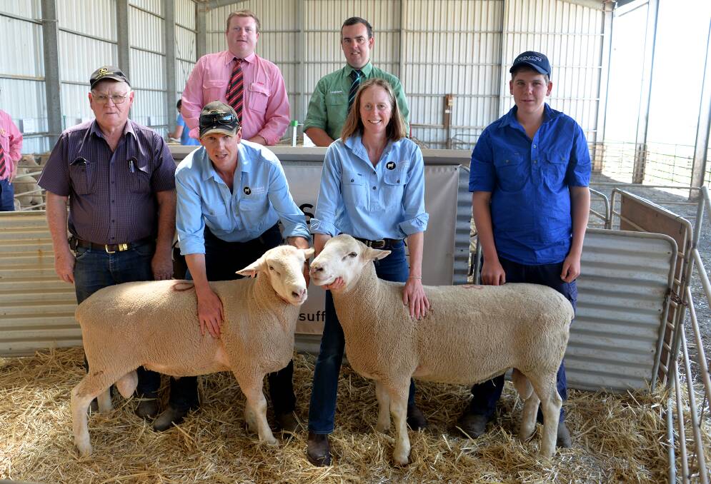 TOP DUO: Troy and Nette Fischer (front centre) hold the two $1800 top price rams with buyers Merv Robinson, Jamestown, and his grandson Henry (right). On the rostrum is Elders' Conor Lamond and Landmark's Peter Marschall.