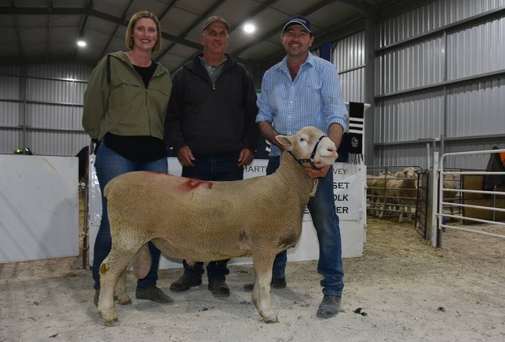 GREAT CAUSE: Kirsty and Martin Harvey (holding the ram) with Mark Pridham who paid the $1900 equal top price in the Poll Dorsets. Paxton donated the money to the Buy A Bale campaign.