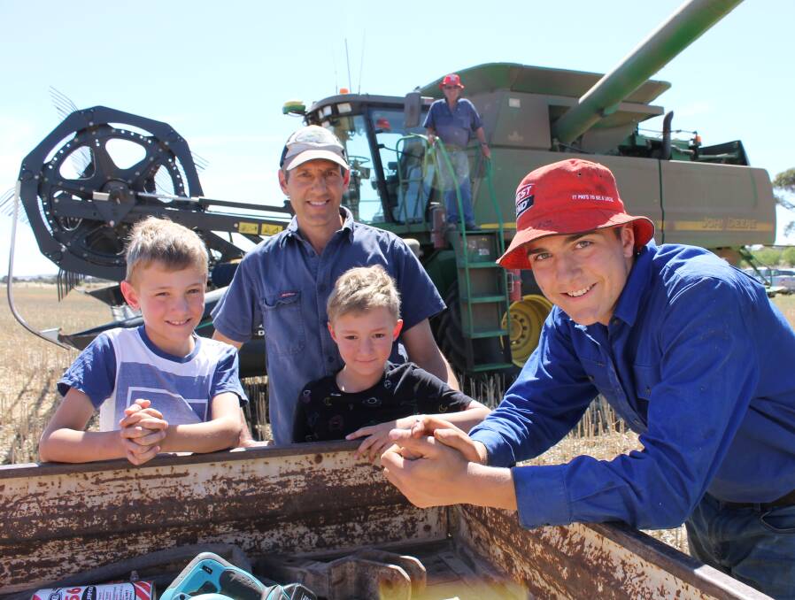 FAMILY AFFAIR: Twins Toby and Darcy Phillips, 9, with father Brett, grandfather Don (at back) and cousin Baxter Raymond, 14, harvesting canola at Woodchester on Sunday.