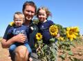 GOLDEN CROP: Freeling farmer Corbin Schuster with daughters Evelyn, 1, and Madeline, 5, and the sunflowers that are raising money for charity.