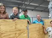 Michael and Sarah Stanton (centre) with children Addison, 7, Cameron, 5, and Lewis, 9, in their new shearing shed near Stokes Bay.