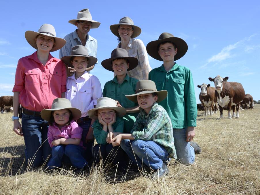 FAMILY AFFAIR: Mallee farmers Josh and Peri McIntosh (back) with their Border Park Organics Hereford beef herd and their seven children - (middle) Eliana, 14, Aleida, 10, Elias, 8, Abran, 12, (front) Aurelia, 2, Malachi, 4, and Gilead, 6.