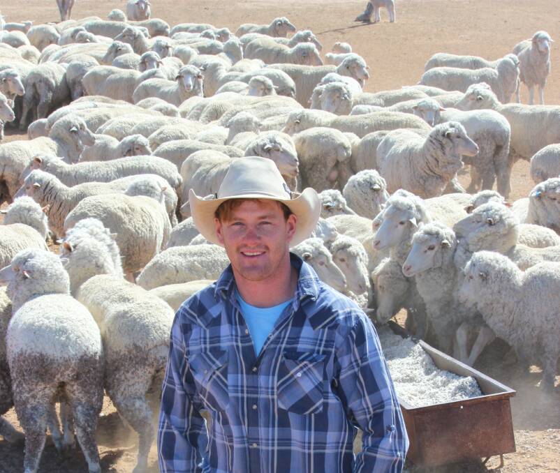 Thomas Burnett feeding out cottonseed to ewes and lambs on Tuttawa, 70km south of Dirranbandi in northern NSW. 