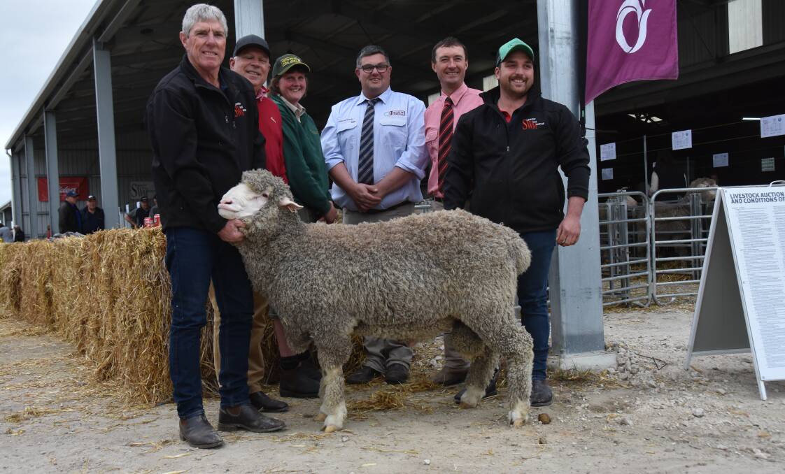 SWM stud principal Richard Harkness holds the $9200 sale topper with Elders district wool manager Trevor Smith, buyer Alison Henderson, Hendowie Poll Merino stud, Caltowie, Quality Livestock's Dave Whittenbury, Elders' Steven Doecke and SWM's Darius Cosgrove. Picture by Catherine Miller 