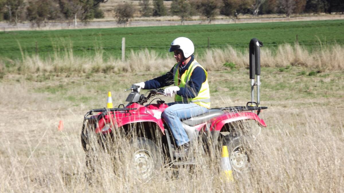 SAFETY GEAR: A rider wearing a helmet riding a quad bike with a roll-over device. Rural doctors say every new quad bike should be sold with a rollover protection device. 