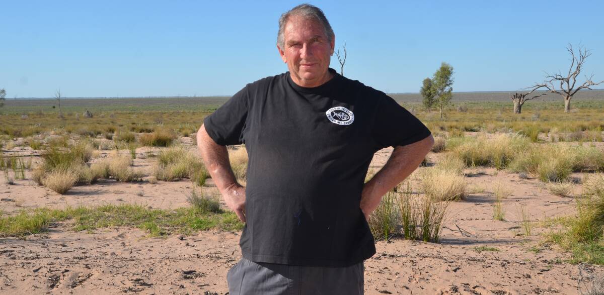 Darling River Action Group president Ross Leddra stands in the dry Lake Menindee. The NSW government's water savings project could be the nail in the coffin for the lake, which has not filled since 2017. 