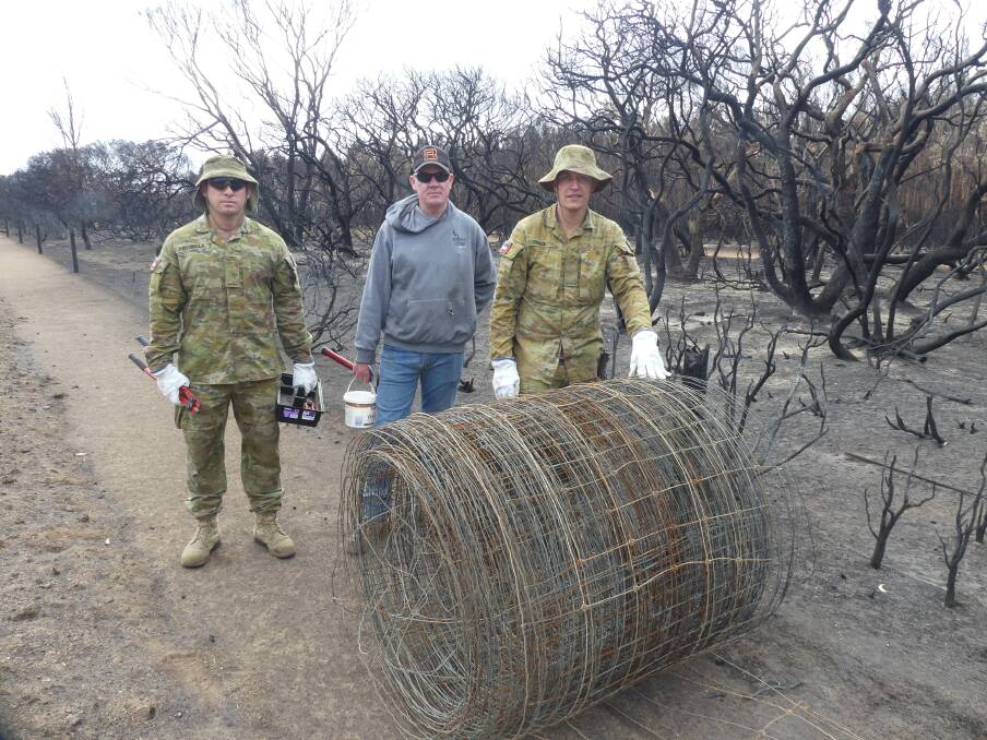 Brian Robins of Turkey Lane Merinos cleans up fences with Army Reservists Nicholas Pryzibilla and Joel Trace of the 10/27 Brigade from Keswick, Adelaide. 