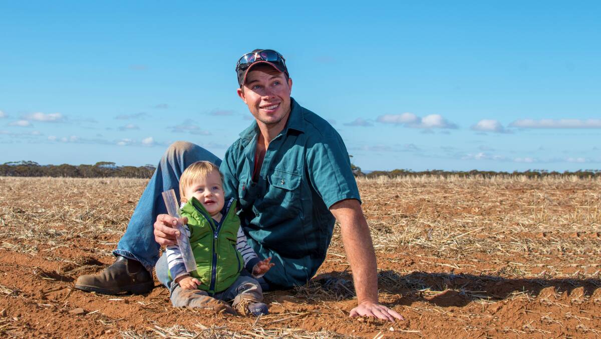 NEXT GENERATION: Hayden Graetz, Sedan, with his 13-month-old son Eddie in a Mace wheat-sowed paddock.