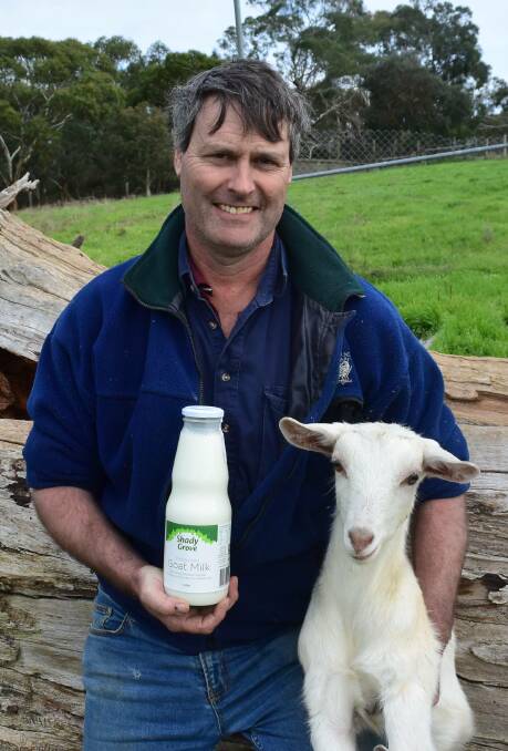Mr Whittaker with a January-drop Saanen doeling from his herd, and a bottle of the dairy's milk.