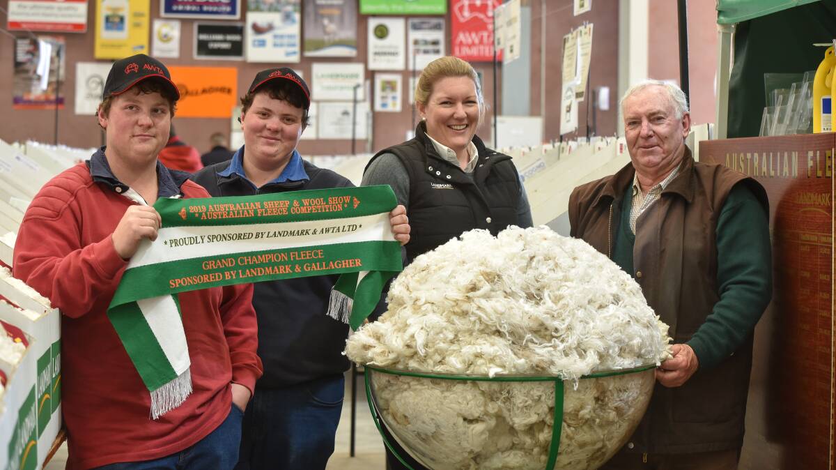 Last year's National Fleece Competition winners Darren, William and Stephen Glen, Wattle Bank Merino stud, with competition convener Candice Cordy (second from right), and the champion fleece. Photo by Ruby Canning.