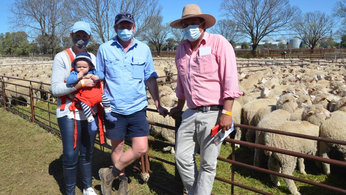 BUYERS: Jess, George and baby Archie Commins, Darlington Point, NSW, with Elders agent Cameron Townsend, who bought wethers at Hay, NSW.