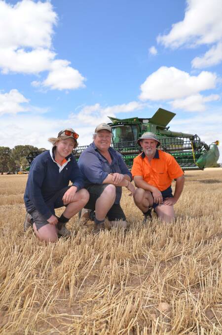 CONSISTENCY GAIN: Dylan and Lachlan Wood with farmhand Tim Wandel in harvested barley at Owen. 