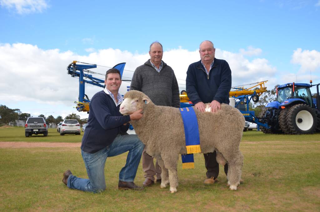 TOP RAM: Collandra North Poll Merino stud principal Sydney Lawrie, Tumby Bay, holding the Elders Hogget of the Year, White 35, with competition judge Roger Polkinghorne, Charinga Merino studs, St Arnaud, Vic, and Graeme Lawrie, Tumby Bay. 