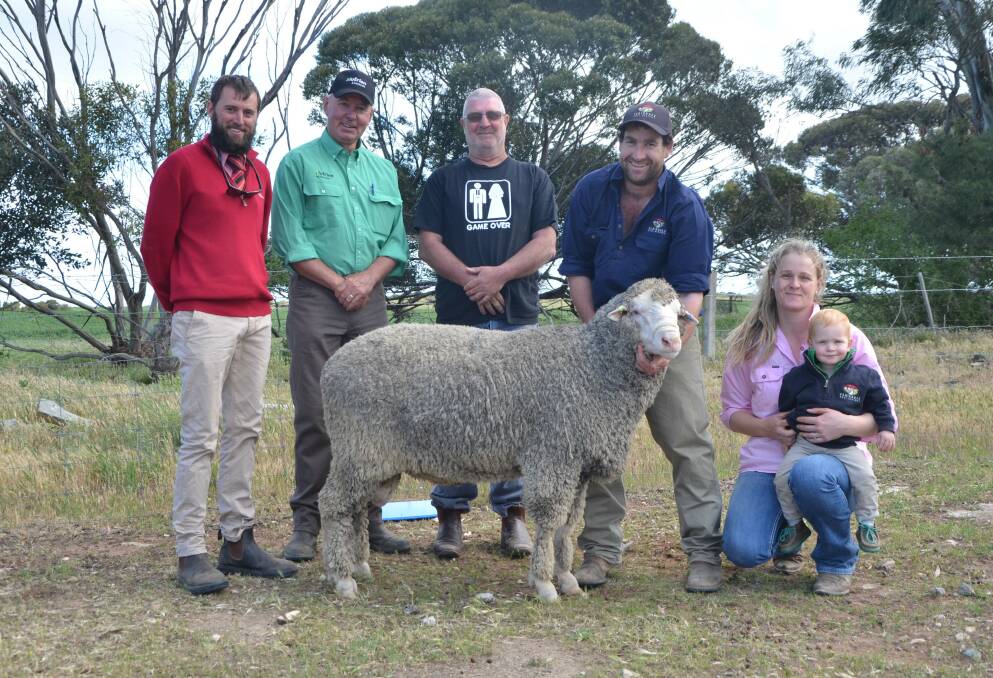 ISLAND BOUND: Elders' Justin Robertson, Nutrien's Richard Snoswell and top-price ram buyer Dale Paxton, Vivonne Bay, Kangaroo Island, with the $6000 purchase, held by Flairdale's Matt Lehmann, with Elle Watson and their son Darcy.