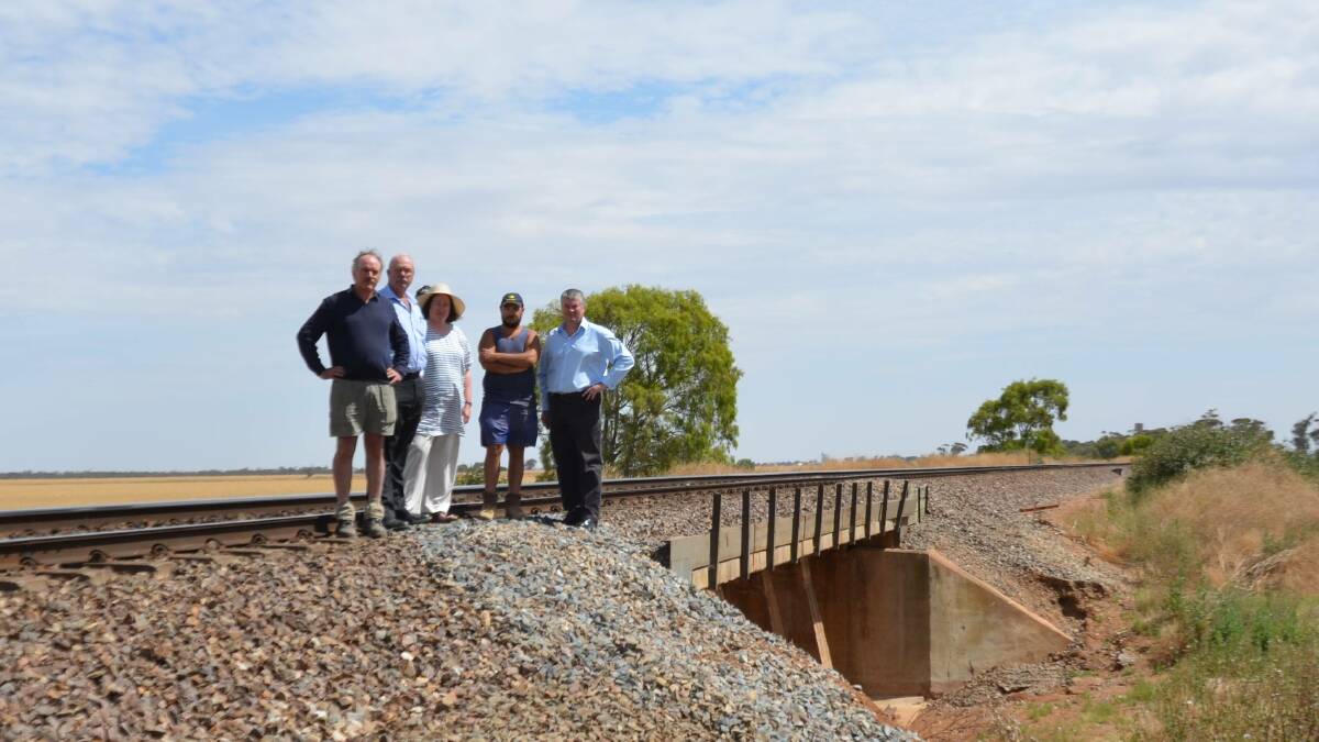 FED UP: Locals Richard Verner, Gary Hunt, Irene Verner and Shane Farrugia with Stephen Griffiths next to the rail track which was inundated with water during the early October floods, due to a lack of culverts and drainage.