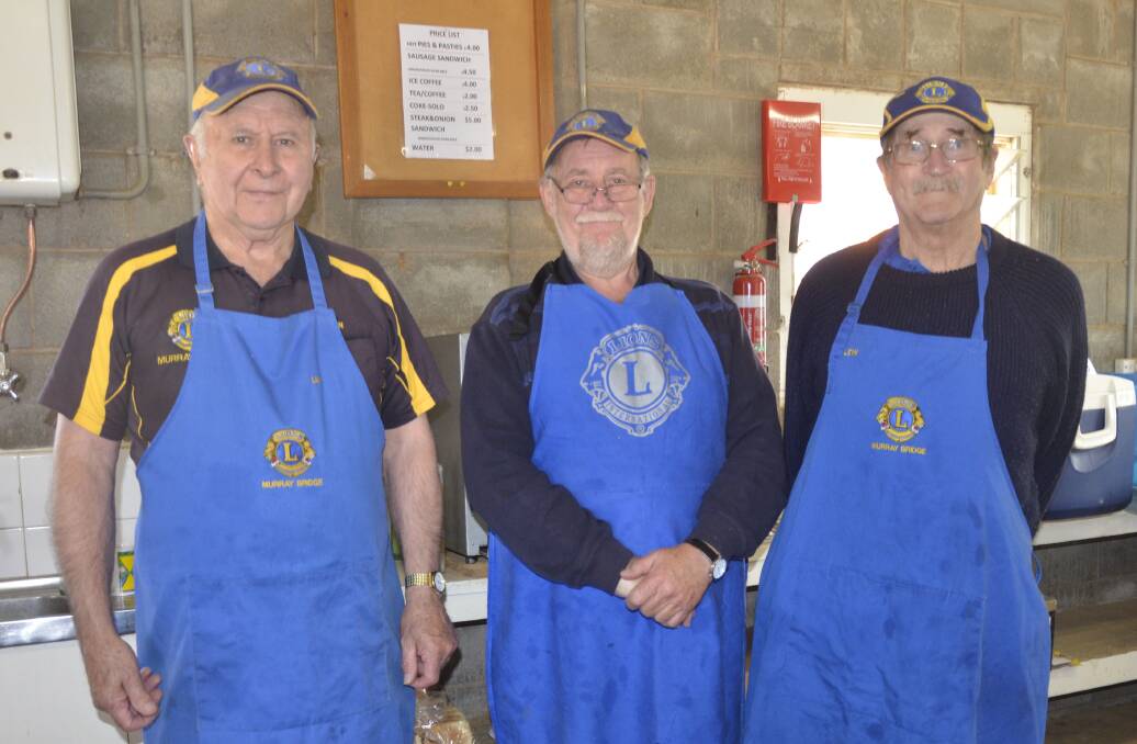 APRONS OFF: Serving up their last barbecue for the season at the Murray Bridge saleyards on Monday were Lions members Ian Hollick, Paul Wade and Lew Webb.