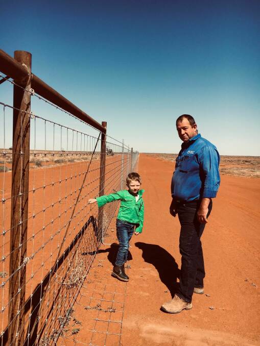 Mulyungarie Station manager Dean Lovis-Hotchin and his son Wyatt, 7, stand at the new dog fence. Picture supplied