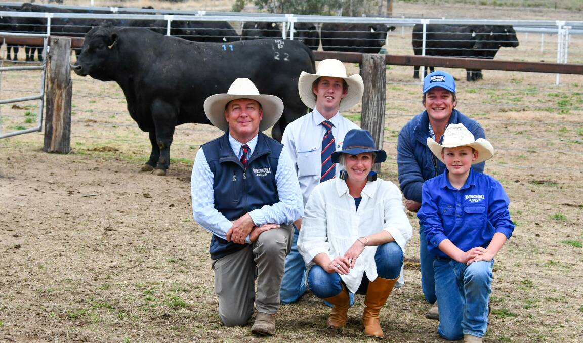 Kneeling together are Sinclair, Jo and Barnaby Munro of Booroomooka Angus while behind them is Davidson Cameron and Co agent Nick Rogers and Waldo Thompson representing buyers Bridgewater Angus, Black Mountain, who paid $40,000 for the top price bull. 